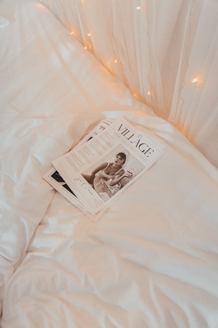 Warm and cozy bedroom scene featuring a magazine on a bed with soft lighting.